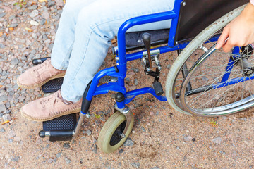 Legs feet handicap woman in wheelchair wheel on road in hospital park waiting for patient services....