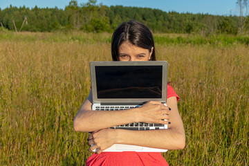 Caucasian girl with a laptop on the nature. Copyspace