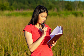Caucasian girl with a notebook on nature