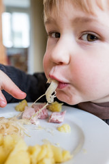 enfant mange choucroute avec les doigts