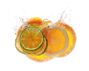 Beautiful bright glowing slices of citrus in a spray of water isolated on white background