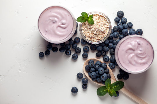 Two Blueberry Yogurt In Glasses On A White Table, Top View, Ingredients For Cooking Diet Food