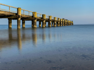 Obraz premium Wooden pier at the shore of the ocean 