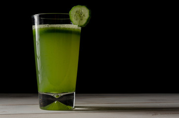 Healthy green juice or smoothie on the dark background