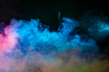 Backlit smoke abstract texture in pink blue yellow on black background.