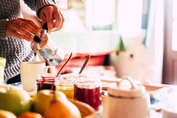 Close up of woman caucasian hands serving and doing traditional coffee dor breakfast  morning time - bright image with food and drinks at home