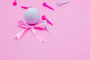 Golf ball with tee on pink background