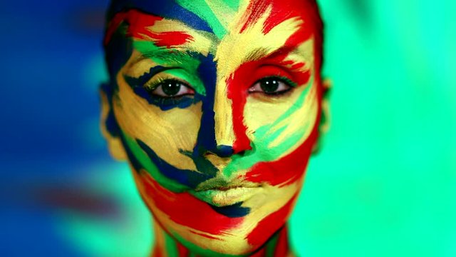 Color face art and body paint on woman for inspiration. Abstract portrait of the bright beautiful girl with colorful make-up and bodyart.