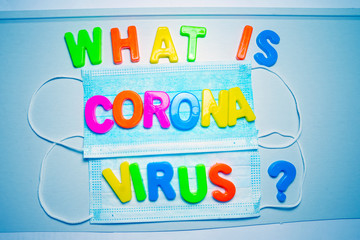 What is Coronavirus, the text is written in plastic letters in different colors on background with protective masks.