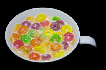 CEREAL WITH MILK, IN A WHITE COLOR RATE, ON A DARK SURFACE