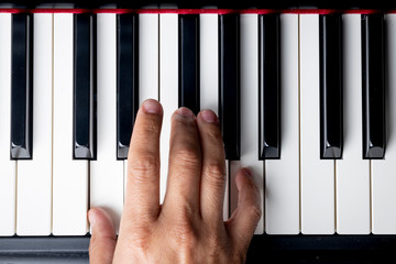 right hand playing a D Major, chord on the piano