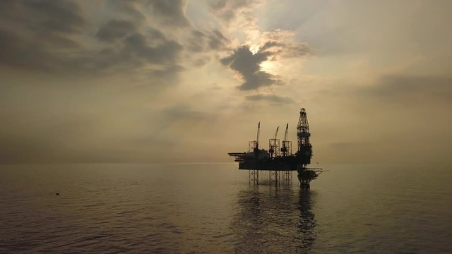 Aerial view of the jack up rig shot during sunset time. Fly around the jack up rig with a drone.