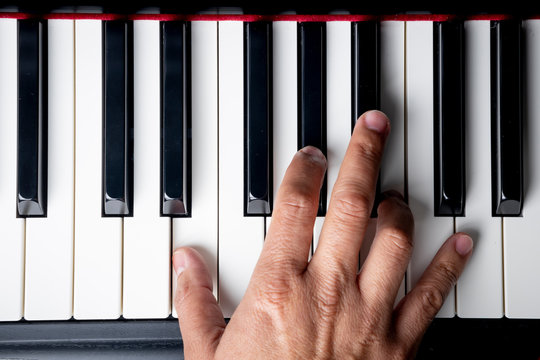 right hand playing a E Major chord on the piano