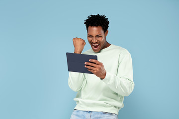 Happy african man looking at tablet.