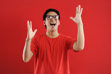 Fototapeta premium Young asian man happy and excited expressing winning gesture. Successful and celebrating