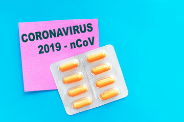 Handwriting text CORONAVIRUS 2019-nCoV on pink and blue background with white pills, blister, tablets. Novel new Wuhan coronavirus disease from China, Pneumonia virus pandemic protection concept.