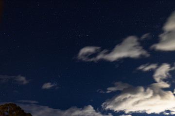 starry night with crisp sky and some clouds with a lot of constellations visible as well as some...