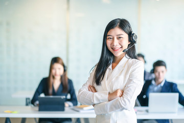 Business woman using headset phone in a call centre. Team of business people working for communication and consulting people at customer service office.