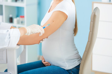 Obraz premium Doctor vaccinating pregnant woman in clinic