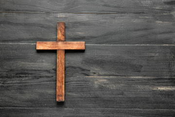 Christian cross on wooden background