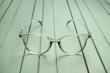 Stylish eyeglasses on wooden table
