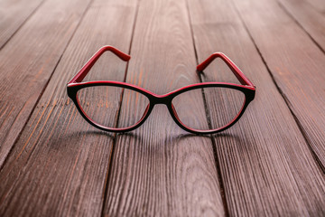 Stylish eyeglasses on wooden table