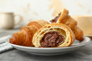 Plate with tasty sweet croissants on table