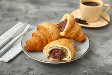 Plate with tasty sweet croissants on grunge background