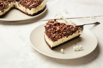 Plate with piece of chocolate cheesecake on white background