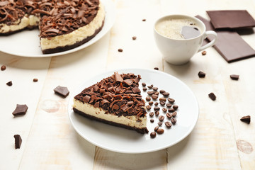 Tasty chocolate cheesecake with coffee on table