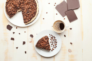 Tasty chocolate cheesecake with coffee on table