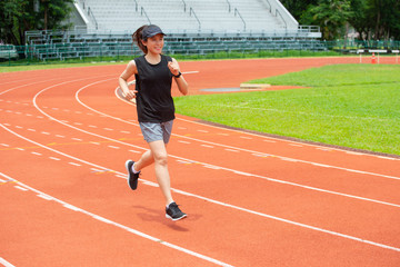 Obraz premium Portret kobiety biegacz lekkoatletka szczęścia uruchomiony w bieżni na stadionie. Bieżnia to gumowana sztuczna nawierzchnia do biegania do lekkiej atletyki.