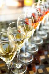 Wine tasting set in the light summer environment. Custom wine tasting concept. Glasses of wine on the glass table and outdoor background