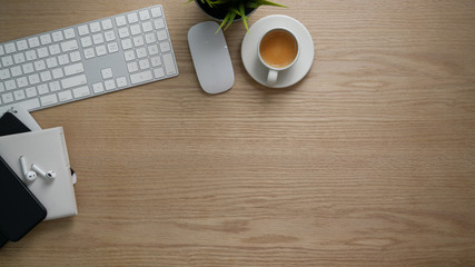 Overhead shot of workspace with copy space, office supplies and coffee cup on wooden table