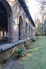 An old brick millitary building in a park used for a picnic area