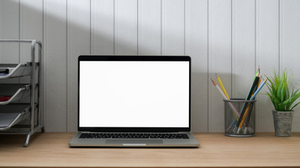 Close up view of minimal workspace with blank screen laptop, office supplies and decorations
