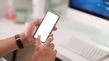 Close-up view of businessman using blank screen smartphone