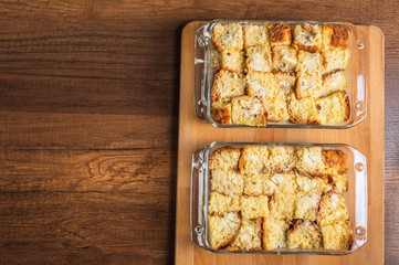 Bread pudding in glass container on wood texture surface table top background.