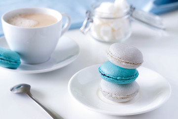 Macarons on a white saucer with tea