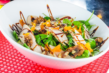 Fresh salad from greens,ruccola,mango on white plate.