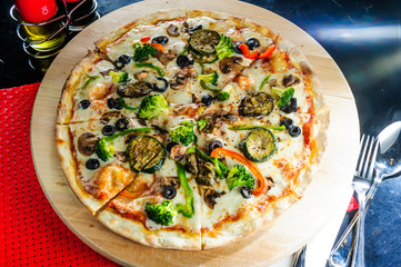 Hot pizza slice with melting cheese on table.