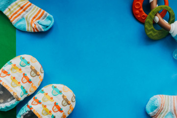 soft slippers slippers made of eco-friendly natural fabrics with teething toy on a smooth blue background and an empty place for an inscription