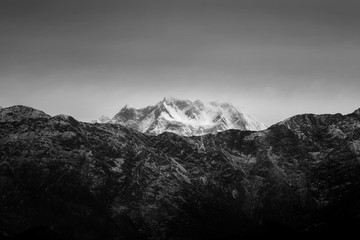 Black and white glacial mountain peak under dark sky