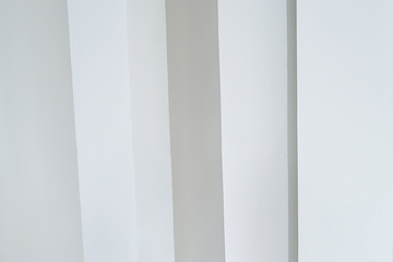 vertical white columns against a white wall