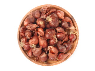 Top view of natural organic fresh raw red shallot onion on round wooden plate isolated on white background.Taiwan's red onion is water droplets type,skin is red. For cook. Food and vegetable concept.
