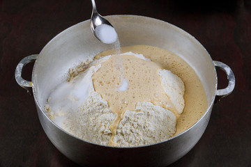Adding salt to yeast dough for making bread.