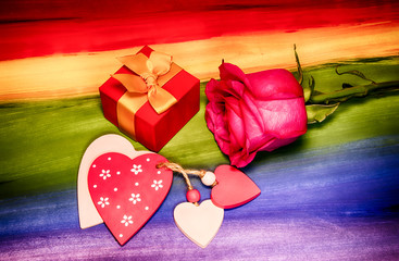 Valentine's card. Gift, hearts and a rose on the background of the LGBT flag. Romantic concept.