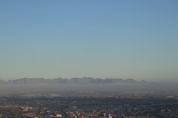 Landscape shot of distant mountains towering over some fog