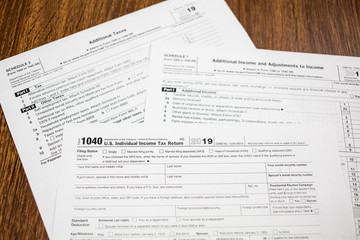 Closeup of IRS 2019 Tax Return form 1040 on wooden table. Taxation reminder.