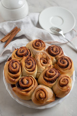 Cinnamon rolls with sugar frosting. With cinnamon sticks and spices, wooden background